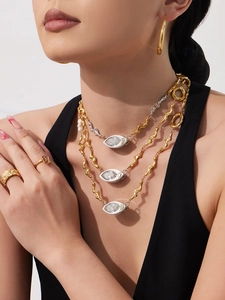 Close-up of layered necklace with marquise-cut zircon pendant and mixed metal wave chains