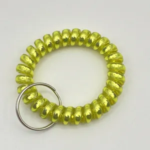 Macro view of bright yellow spiral plastic wrist coil keychain with silver metal ring