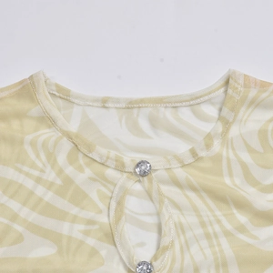 Macro shot of mesh fabric neckline with hollow keyhole and rhinestone button detail