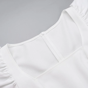 Détail du col carré et de la fermeture éclair invisible au dos de cette robe blanche