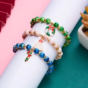 Three-piece Christmas beaded bracelet set with tree, wreath, and candy cane charms