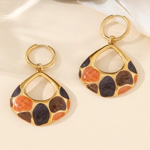 Detail of gold waterdrop earrings featuring orange and purple enamel inlay on silk background