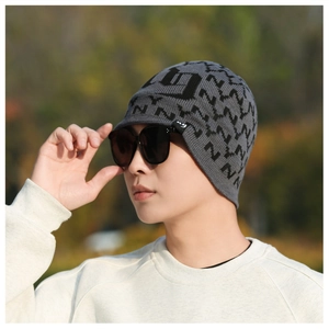 Close-up of men's knit beanie featuring grey and black geometric jacquard patterns