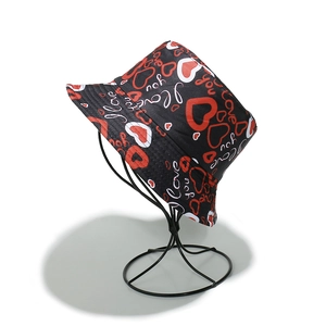 Détail d'un bob noir avec motifs de cœurs rouges et imprimé I love you en toile