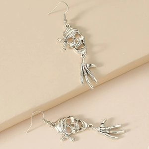 Detailed view of punk pirate skull earrings with bone hand charms on silver hooks