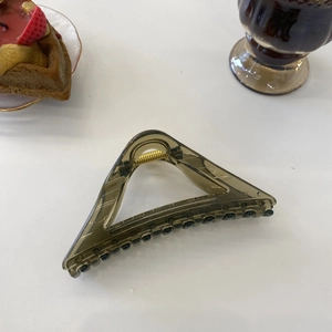 Close-up of amber large triangular hair claw clip with transparent acrylic texture