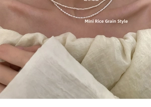 Detailed close-up of double-layered mini rice freshwater pearl necklace on model