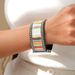 Detail of colorful resin rainbow wide bracelet with rhinestone edges and magnetic clasp