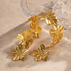 Exquisite gold floral bangle featuring detailed metal petals with a premium textured finish