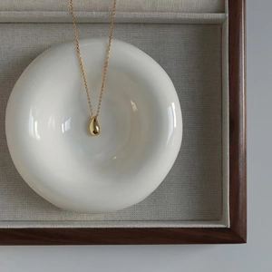 Collana minimalista con goccia d'acqua in oro 18 carati in piatto di ceramica e scatola di legno