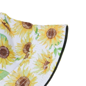 Detailed view of white bucket hat with yellow sunflower print and precise stitching