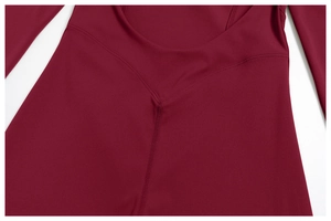 Gros plan sur la couture en V d'un body de yoga bordeaux en tissu très élastique