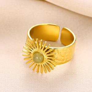 Macro shot of gold sunburst ring with turquoise stone inlay and textured open band