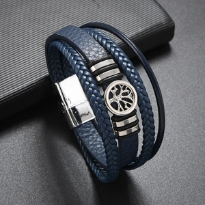 Blue multilayer braided leather bracelet with silver Tree of Life charm on black surface
