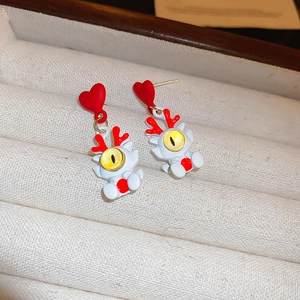 Détail des boucles d'oreilles cœur œil de dragon en acrylique sur un écrin à bijoux
