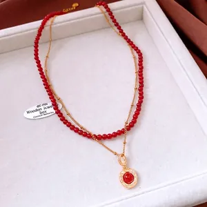 Detailed close-up of double-layer vintage necklace with red tiger eye stone and gold chain