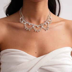 Detailed view of layered rhinestone fringe necklace on model for elegant wedding bridal look