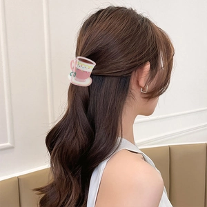 Detail of pink coffee cup hair claw clip worn on hair with cute heart patterns