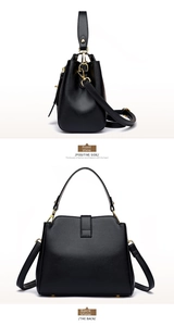 Detail view of black textured leather bucket bag with gold hardware and adjustable strap