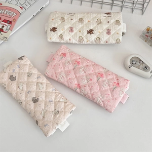 Detailed close-up of quilted floral pencil cases featuring lace trim and cute animal patterns