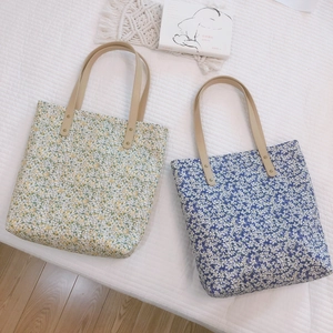 Set of two floral canvas tote bags in blue and yellow with brown leather shoulder straps