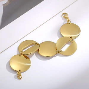 Dettaglio del bracciale dorato in acciaio inossidabile con maglie a dischi geometrici
