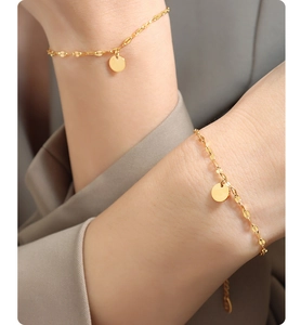 Close-up of minimalist 18K gold plated titanium bracelet with polished round discs on wrist