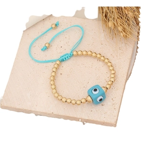 Braided Evil Eye bracelet with blue square beads and gold accents on stone base