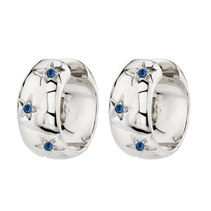 Macro view of silver hoop earrings with blue stones and engraved star patterns