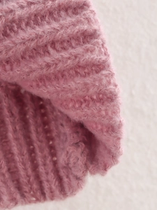 Macro shot of pink chunky knit fabric showing fluffy yarn texture and detailed stitch pattern
