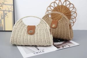 Detailed view of woven straw handbags in beige and light brown with metal swivel locks