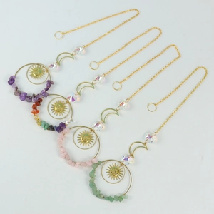 Detail of four golden moon and sun suncatchers with various natural crystal stones