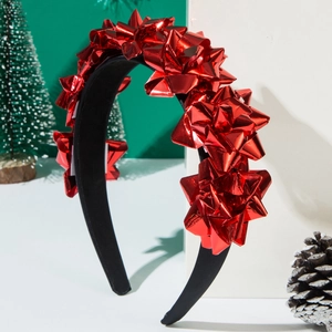 Dettaglio del cerchietto in velluto nero con decorazioni a fiocco rosso lucido per Natale