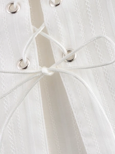 Detail of white fabric texture with silver eyelets and criss-cross lace-up design