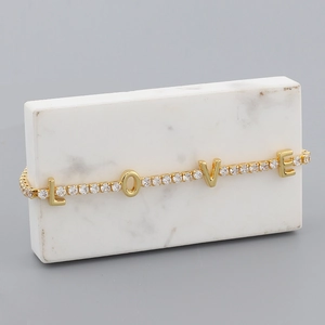 Detailed macro view of gold plated LOVE tennis necklace with sparkling cubic zirconia