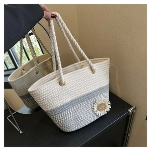 Detail of hand-woven tote bag in cream and blue with white daisy floral ornament