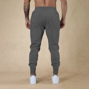 Vista trasera de pantalones deportivos ajustados gris oscuro para fitness de hombre