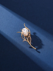 Detailed macro view of golden tulip brooch featuring a baroque pearl and zircon inlay