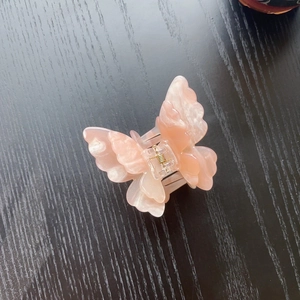 Detail of pink marble textured butterfly hair claw with durable metal spring mechanism