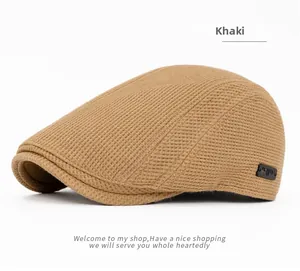 Détail de la casquette plate kaki avec texture gaufrée et étiquette décorative