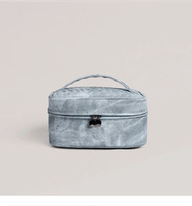 Detail of blue denim toiletry bag with sturdy top handle and silver double zippers