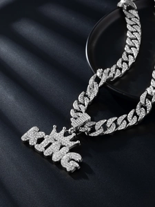 Close-up of iced out silver KING letter pendant with crown on thick Cuban link chain