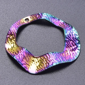 Macro view of rainbow stainless steel earring pendant with a hammered metal texture