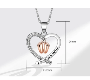 Detail of silver heart necklace with baby feet and I love you MOM engraving