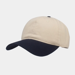 Detail of a two-tone baseball cap featuring beige crown and navy blue visor stitching