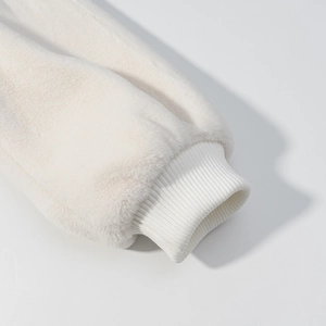 Vue détaillée de la manche en fausse fourrure blanc chaud avec poignet en maille
