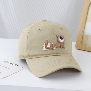 Close-up of beige cotton kids baseball cap featuring a 3D bear patch and Luck embroidery