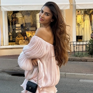 Details des rosa schulterfreien Plisseekleids mit Laternenärmeln und Satin-Struktur