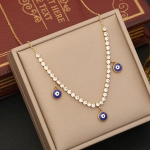 Golden stainless steel evil eye necklace with blue pendants and clear zircon on a jewelry box