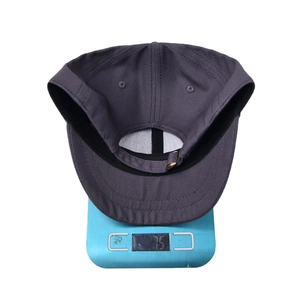 Detailed view of dark grey baseball cap interior construction and 75g weight on scale